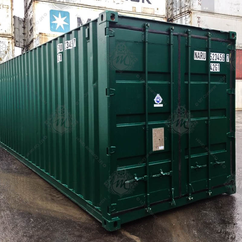 Ein dunkelgrüner 40-Fuß-Seecontainer mit der Aufschrift „NARU 523456-7“ steht geschlossen auf einem nassen Boden.