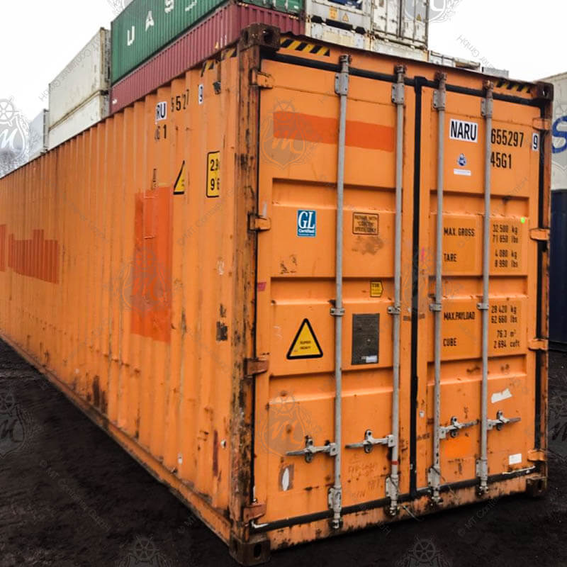 Ein orangefarbener 40 Fuß High Cube Lagercontainer mit der Aufschrift NARU 655297-9 steht auf einer dunklen Erdfläche.