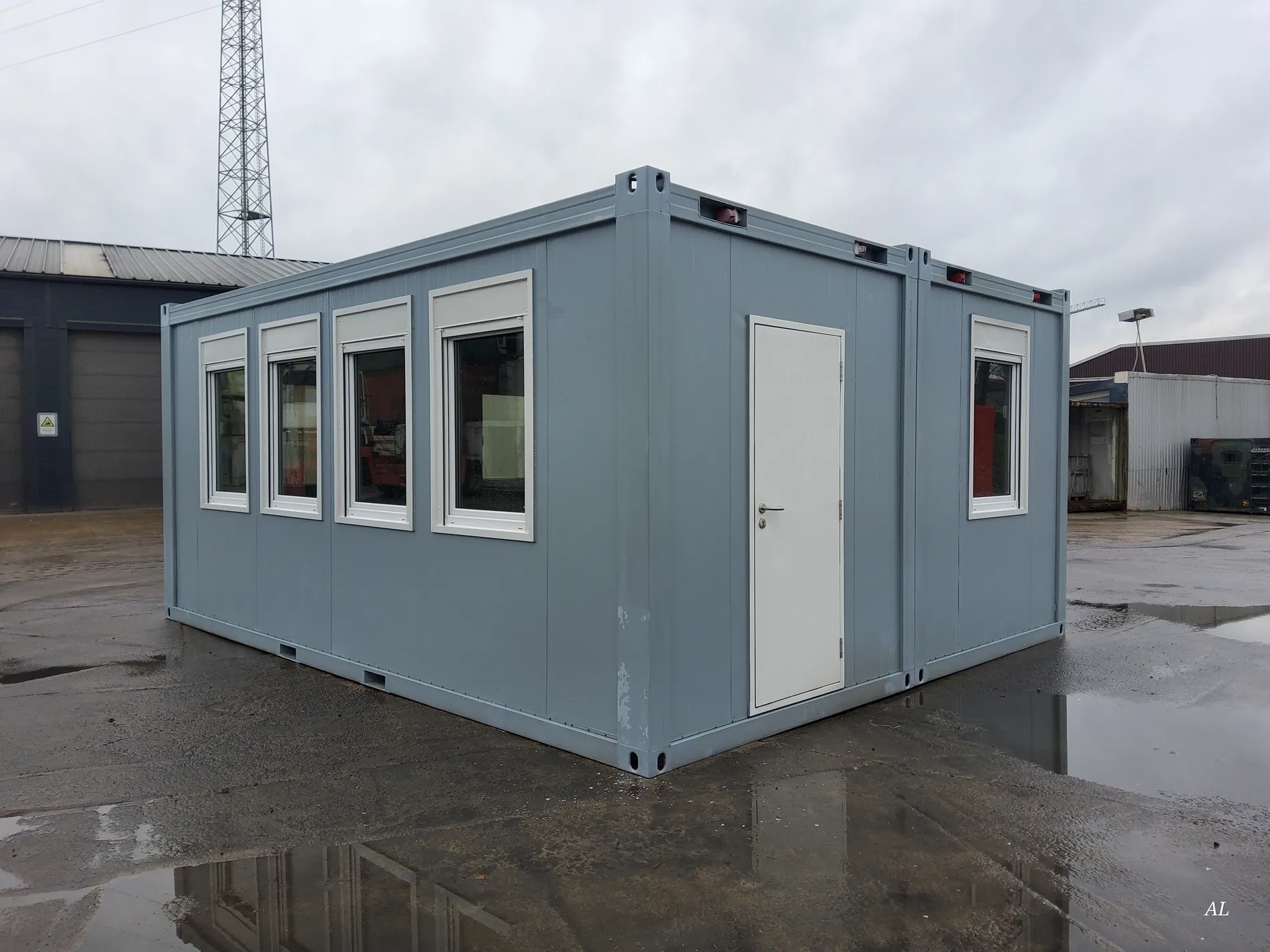 Graue Bürocontainer-Doppelanlage von außen mit vier Fenstern und Eingangstür