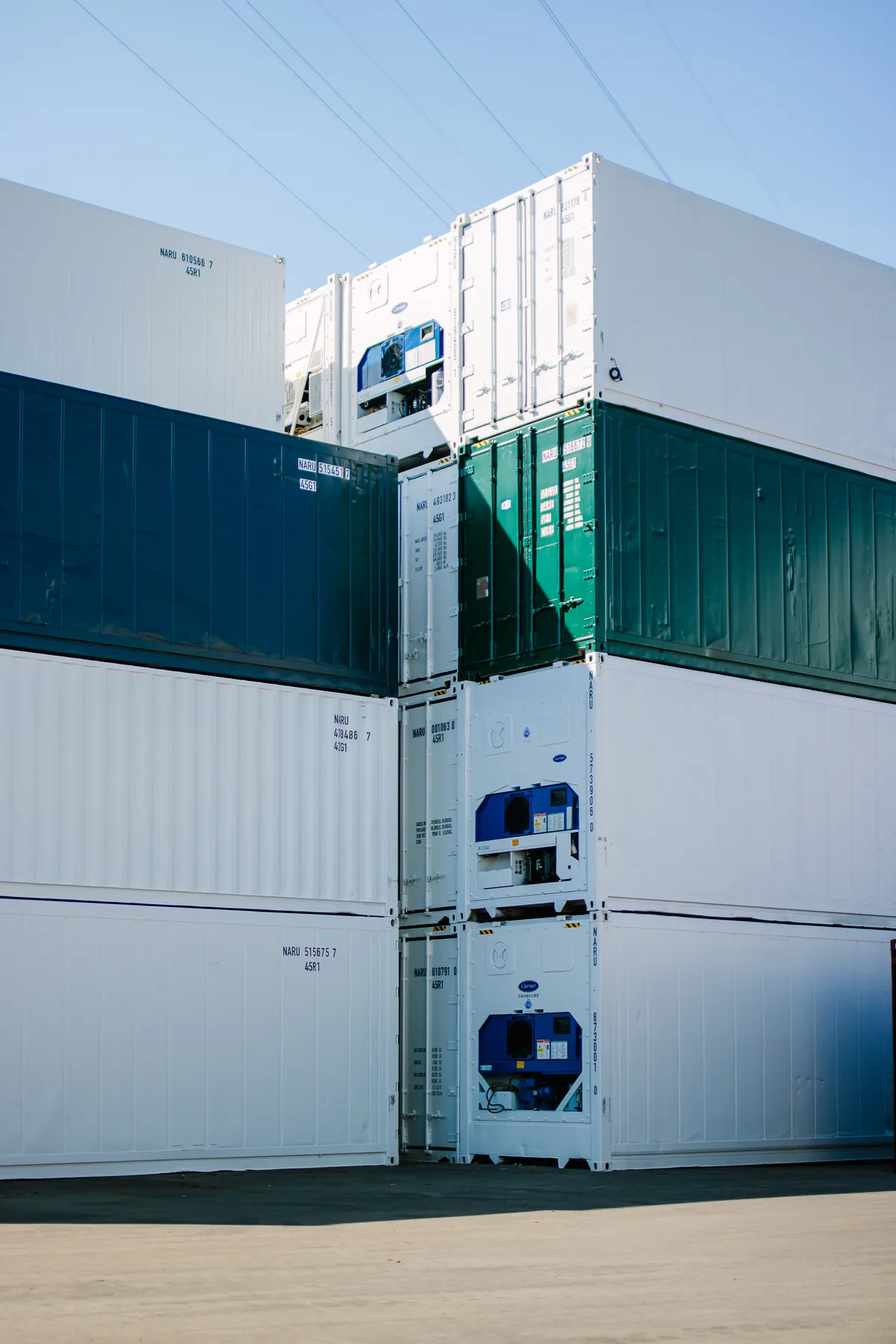 Gestapelte Kühl- und Standardcontainer im Depot – Reefer mit Carrier-Aggregaten aus dem Bestand von MT Container