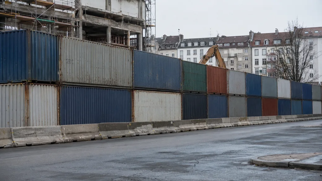 Containerwand schirmt eine Abrissbaustelle in Wohngebiet gegen Lärm ab